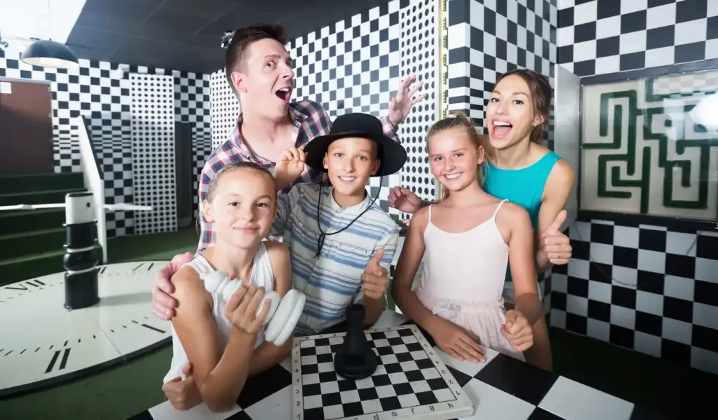 Escape game échecs : activité ludique en famille Famille joyeuse dans un escape game échecs au décor en damier avec un labyrinthe.